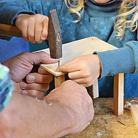 Holzwerkstatt - Hier wird ein Tisch für ein Kuscheltier angefertigt, es gibt aber auch kleine Betten, Boote, Flugzeuge, Bögen, Instrumente, Skateparks und viele weitere Ideen der Schülerinnen und Schüler, die in diesem Raum Gestalt annehmen.  